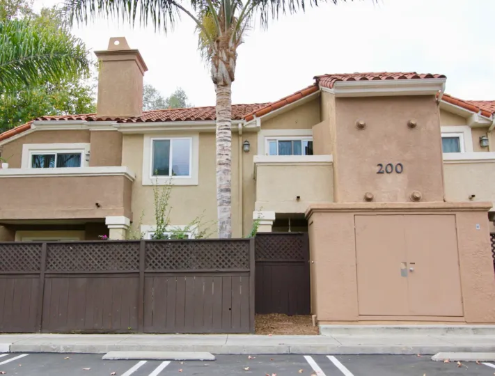 View of The Bluffs Community in Oceanside, CA with Palm trees and parking