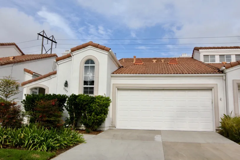 Tall bushes in front of the windows of a house in Villa Trieste Oceanside, CA