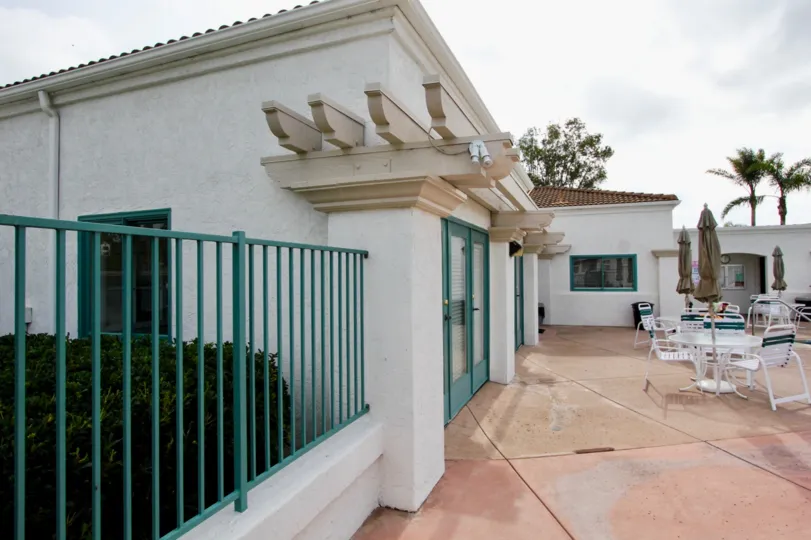 A side view of a patio with columns and teal fence at Villa Trieste