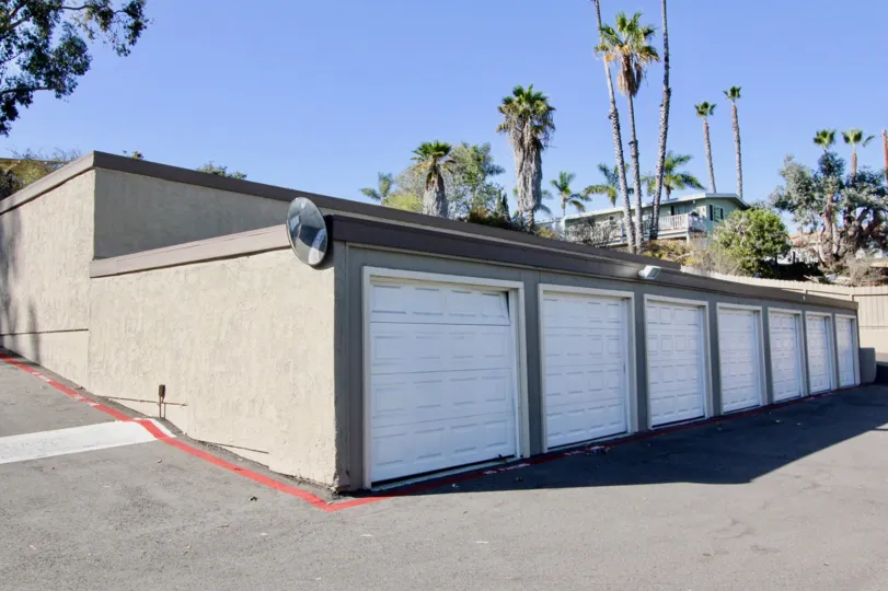 Seven white garage doors on a single story building in Vine Villas at Oceanside CA