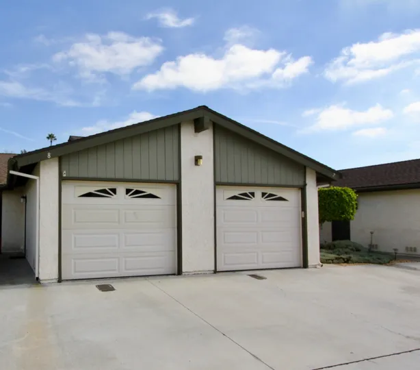 Two grates sit on a driveway in front of garage doors at Vista de Oceana