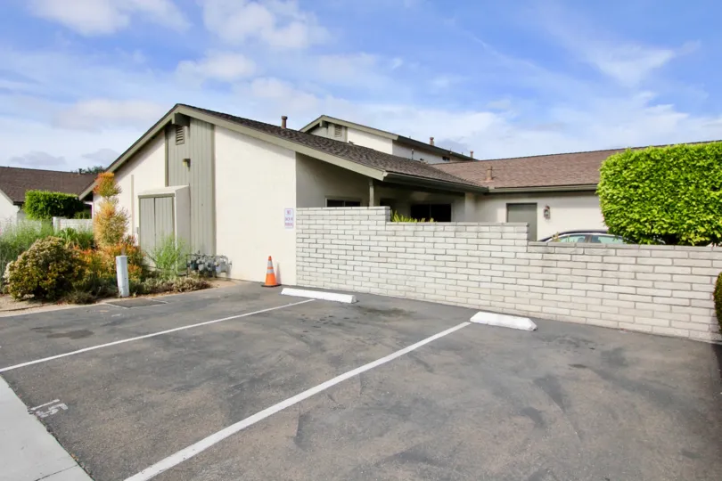 A parking area with brick wall and landscaping at Vista de Oceana