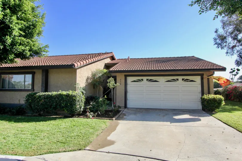 Garage front view with trees and plants near building in Vista Montana