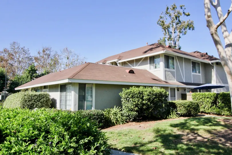 A stately home surrounded by sprawling gardens full of green grass and trees at Whelan Ranch, Oceanside, California