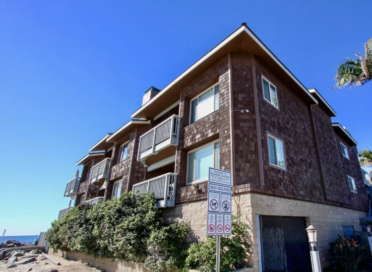A brick building with patios is on a corner in the White Water Village area of Oceanside, CA.