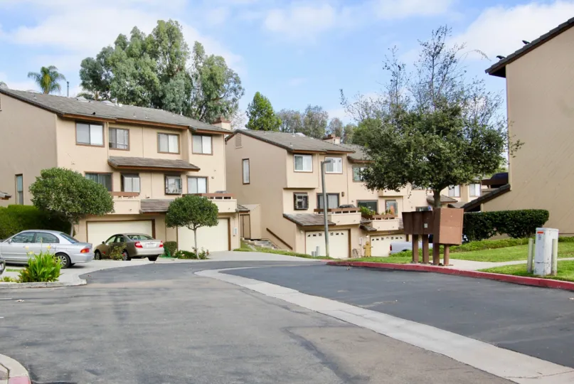 A parking area in front of some town home properties with individual garages at Woodland Ivy