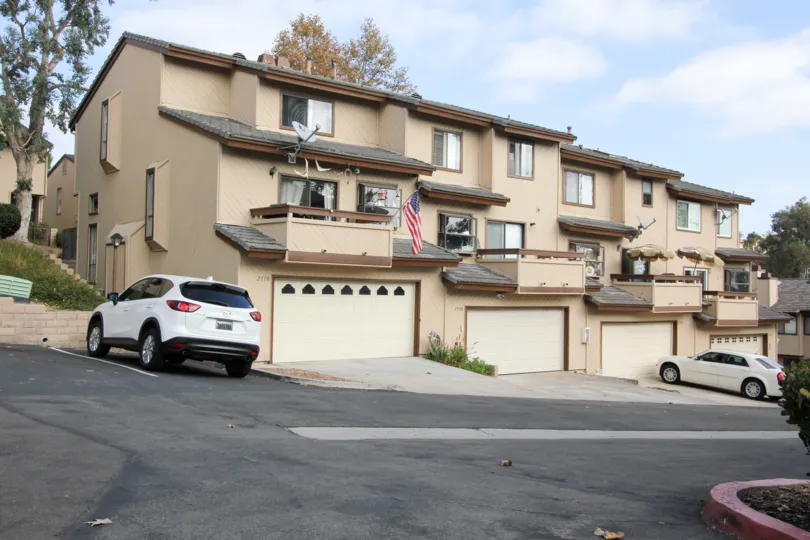 Building on a hill with parking spots and separate parking garages, located at Woodlands Ivy, Oceanside, California.