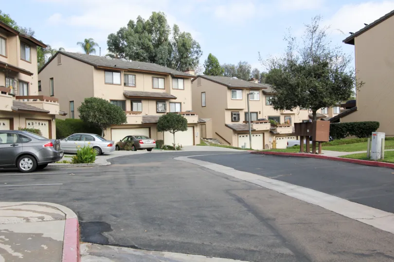 Multiple condos in the Woodlands Ivy community with a one lane road, with white garage doors