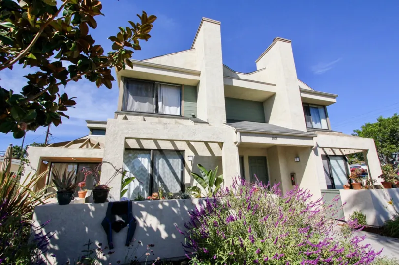A simple two-storey residence in 1076 Opal community with a low, white fence.