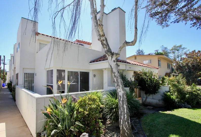 A two-storey residence with white walls and a limp tree in 1531 Missouri community.