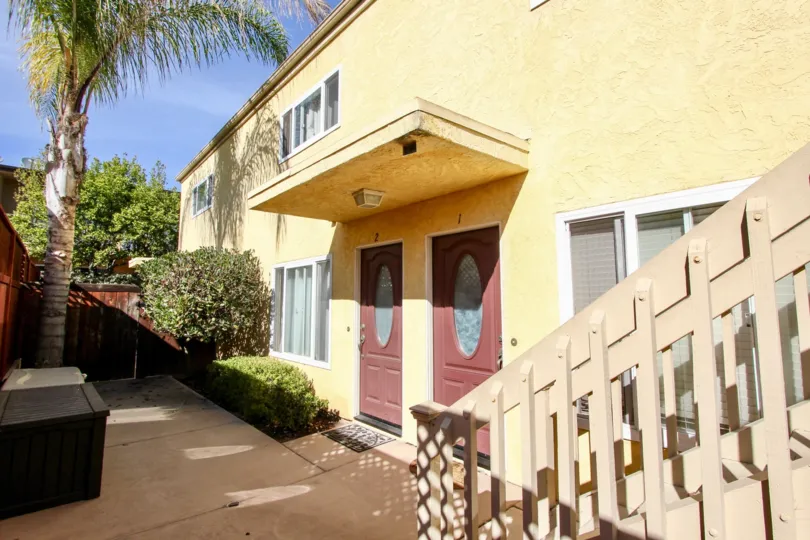 A Bright sunny day with trees and stair case around a yellow colour villa in 1912 Diamond of Pacific Beach