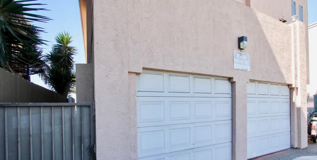 Two white garage doors around a light inside 3802 Riviera Condos at Pacific Beach CA