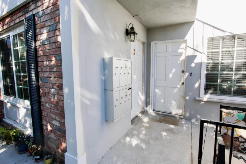 THE BUILDING IN THE 839 SAPPHIRE WITH THE ELECTRIC BOX, GLASS WINDOW, LAMP, PLANTS