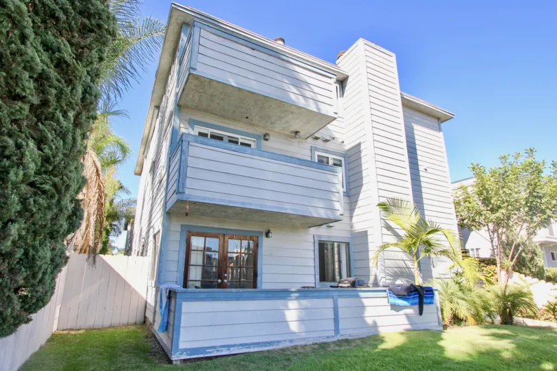 A bright sunny day with a lawn in front of a house with trees in 928 Diamond of Pacific Beach