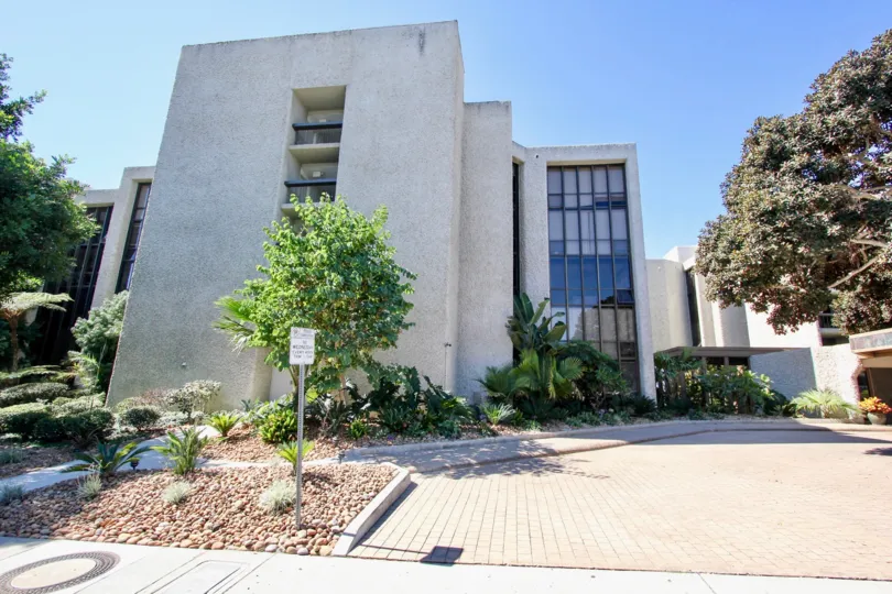 Side to the pathway of apartment in Bay Scene has board with meadows and trees