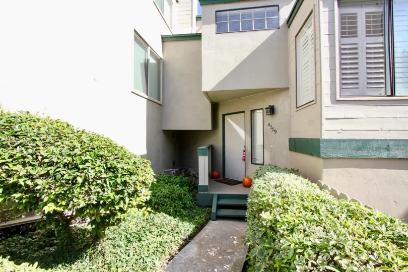A back-door access to the Beach Scene community with shrubs in the yard.