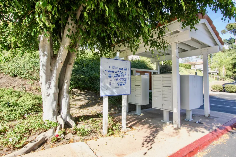 The Bella Pacific entry side with aname board and trees around