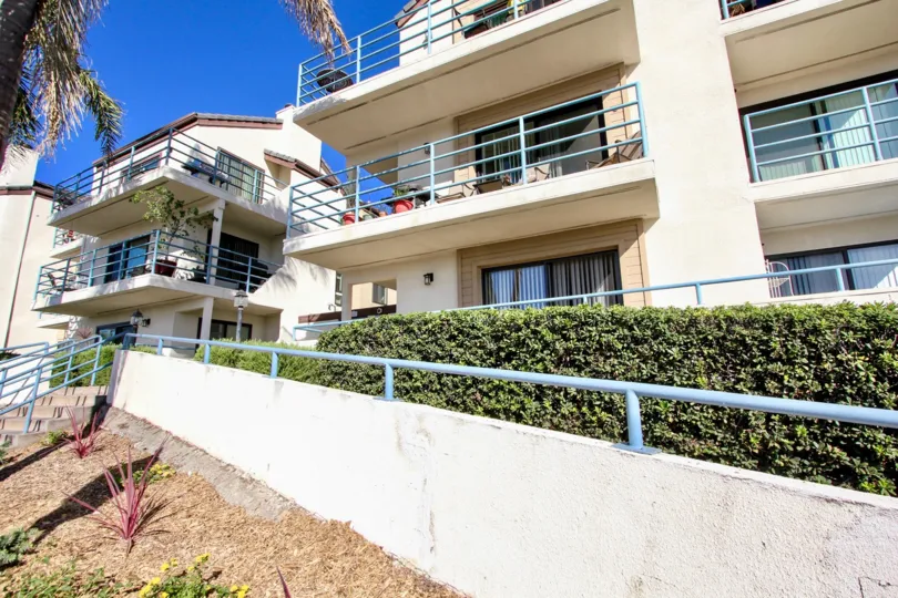A sunny day in the area of Camelot Bay, stairs, condos, bushes, balconies, trees
