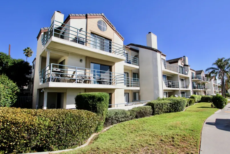 A Bright sunny day with lawn and garden in front of Villas in Camelot Bay of Pacific Beach