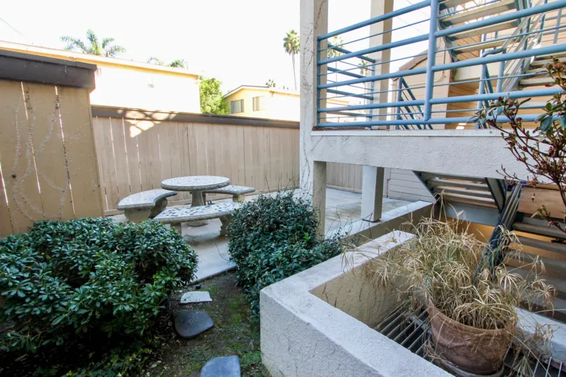 Outside seating on the patio with nice green bushes and plants at Camelot Bach in Pacific Beach, California