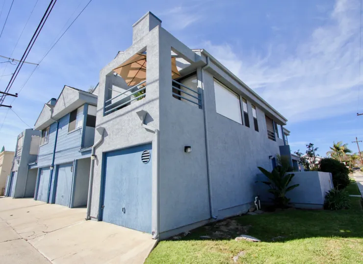 A Bright sunny day with lawn on the side of a house with car parking in Chalcedony Six area of Pacific Beach