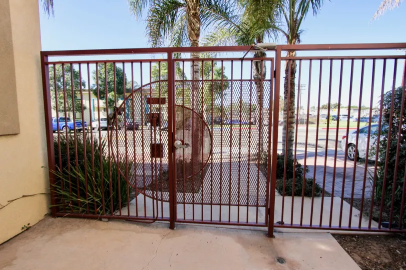THIS IMAGE SHOWS THAT STEEL GATE WHICH HAS BEEN CAR PARKING, TREES, PLANTS