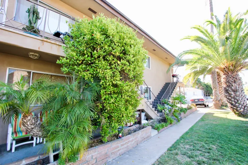 view of a housing in Crown Point. stairs leading to more homes and a lush green yard and trees in front