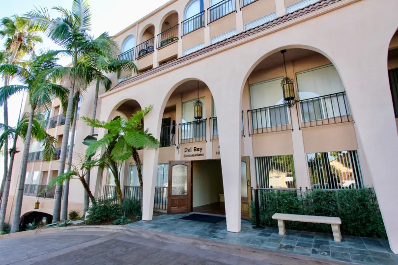 front entrance view of Del Rey, a very clean look with trimmed bushes and trees and clean slight pink paint job
