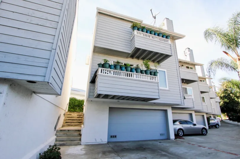 In the balcony of apartment in Diamond by the Bay has Flower pots which is painted by blue color and car is parking