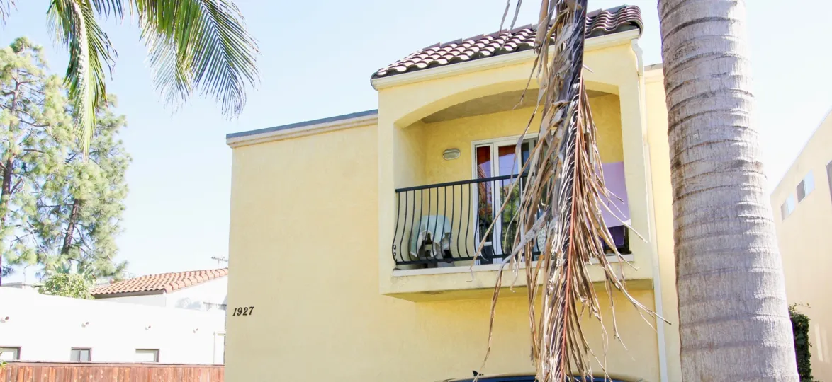 A balcony doors stands partially open on a yellow building at Diamond Club condos