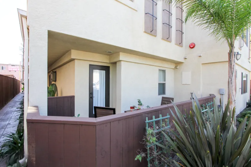 Sit out of big building in the Felspar Townhomes with some plants and chairs.
