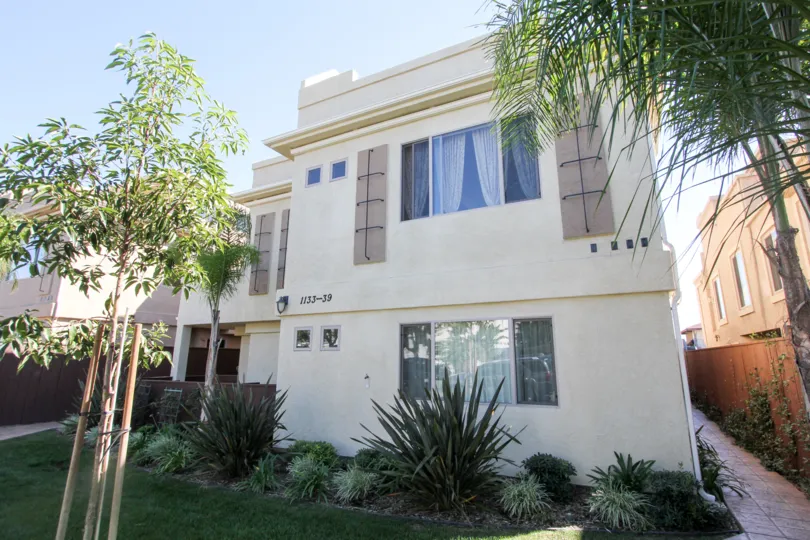 The Apartment in Felspar Townhomes mentioned wtih 1133-39 with bushes and trees