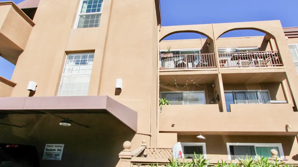 a pleasant day in the la jolla bella with a building that has number of houses in it.