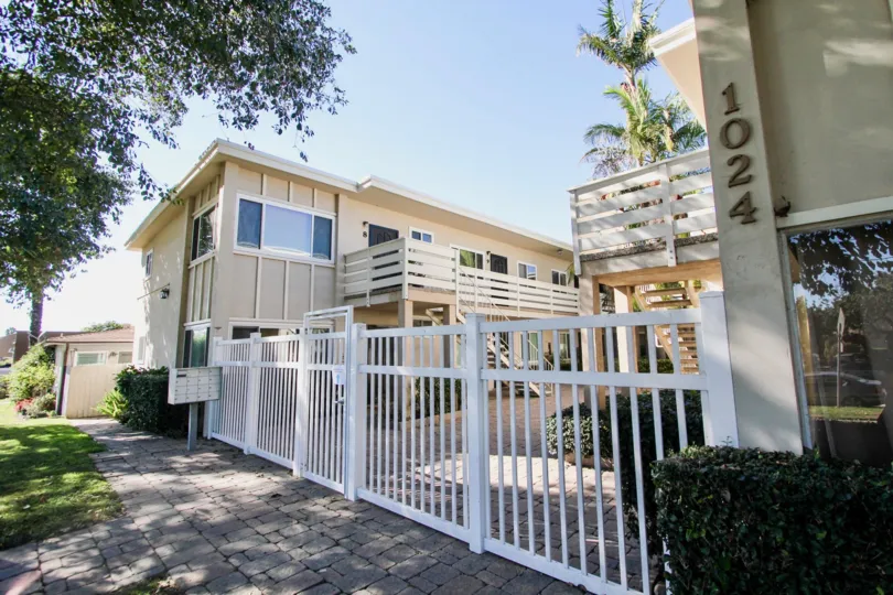 A low-rise residence with gated courtyard and exterior staircase in the Loring Manor community.
