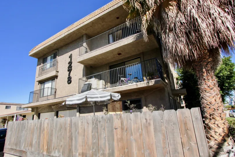A NICE DOUBLE FLOOR HOUSE WITH INFRONT OF BROWN GATE AND TREE