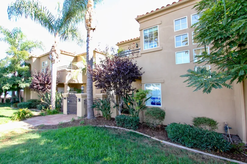 A sunny day in the area of Missouri Street Condos, outside, palm trees, gate, sidewalk, garden