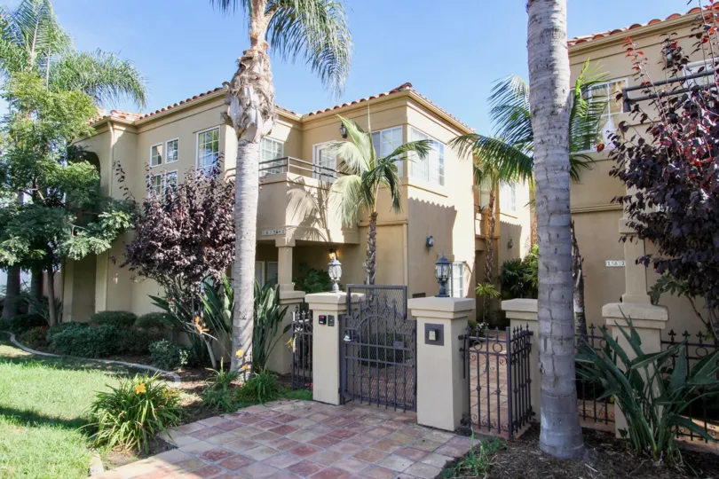 Gated entryway with palm trees and bushes at Missouri Street Condos in Pacific Beach, CA