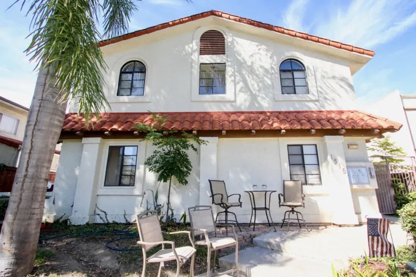 THE 1516 APARTMENT IN THE MISSOURI VILLAS WITH THE CHAIRS, PLANTS, TREES, NATIONAL FLAG