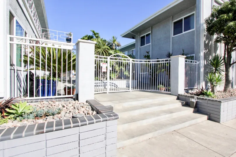 Front side view of gated area on sunny day of villa in Ocean Spray of Pacific Beach