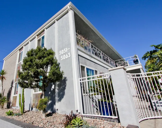 A sunny day in the area of Ocean Spray, outside, gate, fence, trees, balcony, high rise