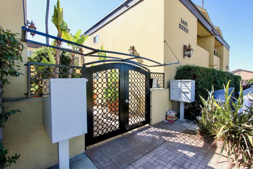 The entrance to the On Reed community with yellowish walls and decorative gate.
