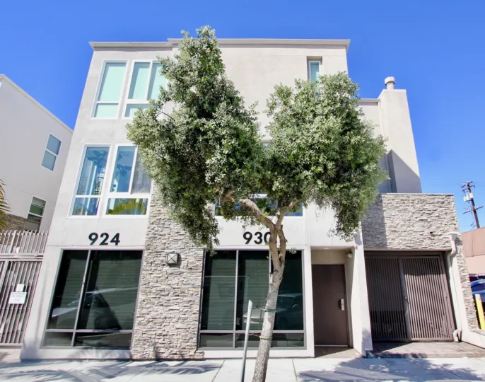 In front of the apartment in pacific Beach Sands has a tree with white flowers