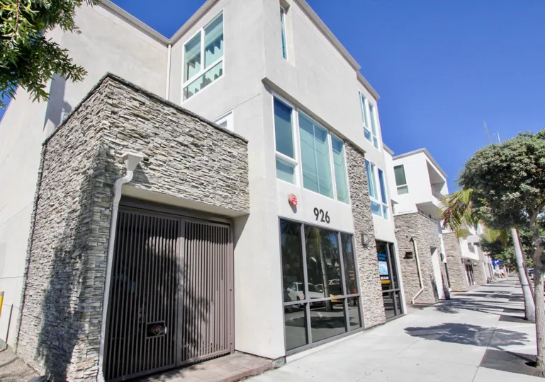 A contemporary townhouse in the Pacific Beach Sands community with stone cladding and grayish paint.
