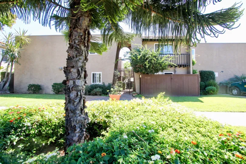 Green lawns and arched entry gated entrance at Pacific Beach Villas in Pacific Beach, California
