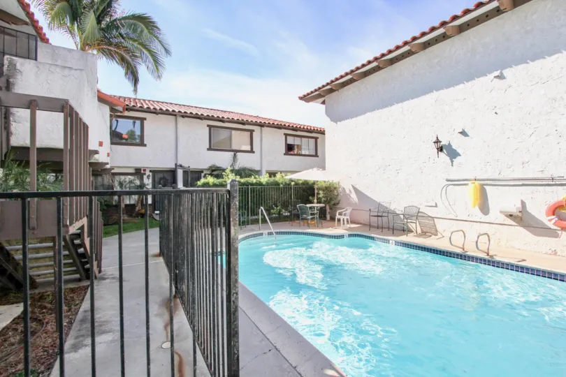 The poolside view of Pacific Pines equipped with seating and gating