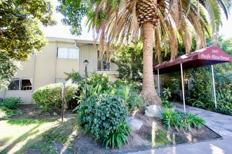 Back side of Estates a wight color building in the Pacific Plaza Terrace with lawn and food path