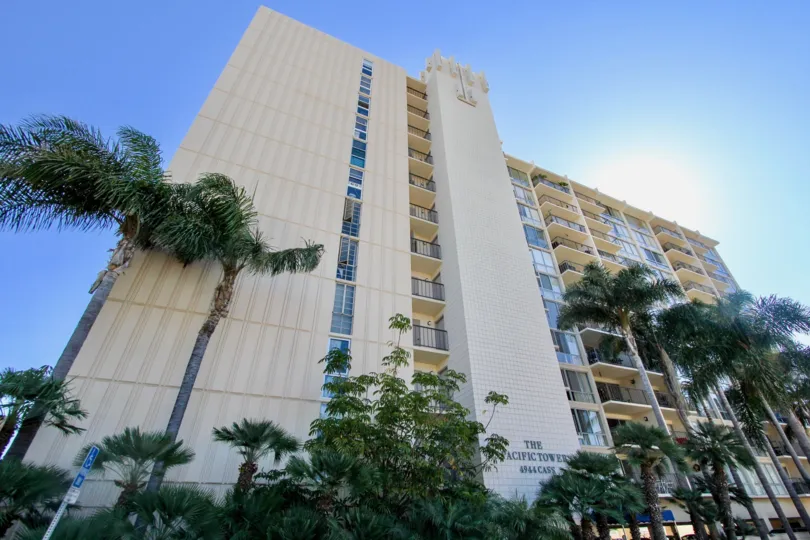 A large apartment building wtih palm tress out front at the bottom, in Pacific Tower, Pacific Beach, California.
