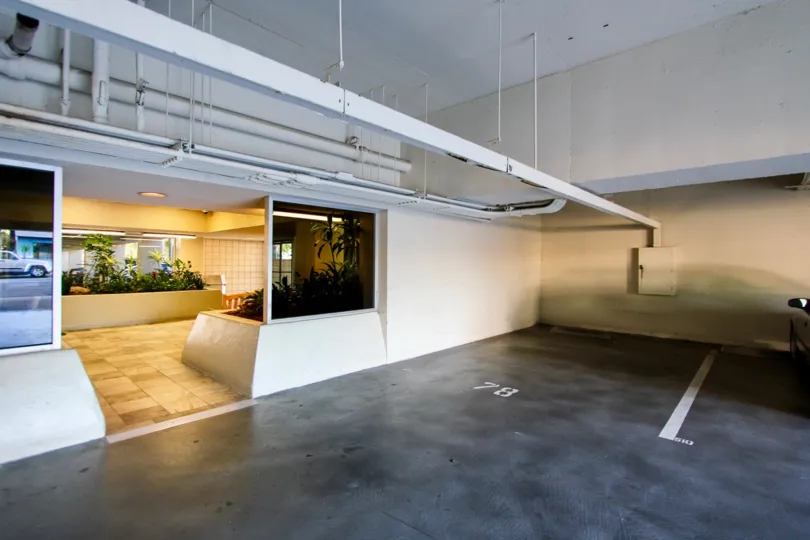 A sunny day in the area of Pacific Tower, parking garage, lobby, dorrway, plants, car