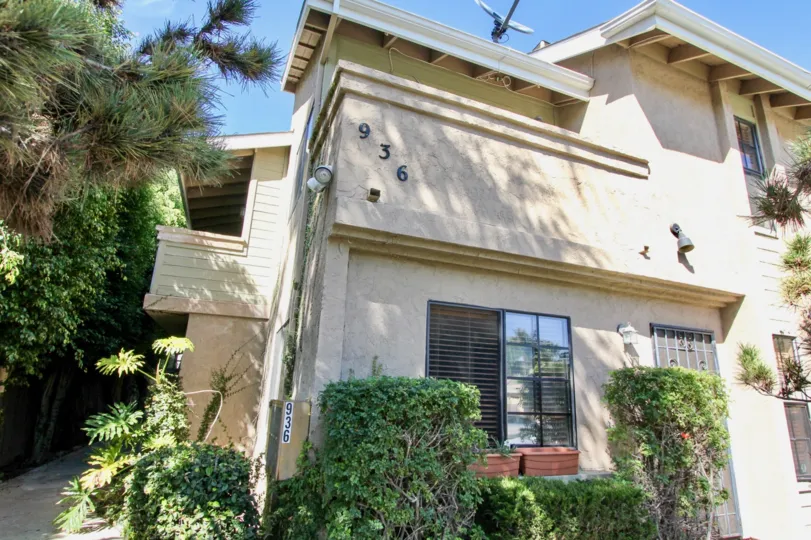 A semi-contemporary residence in the Pacific View Townhomes with wooden cladding and cream paint.
