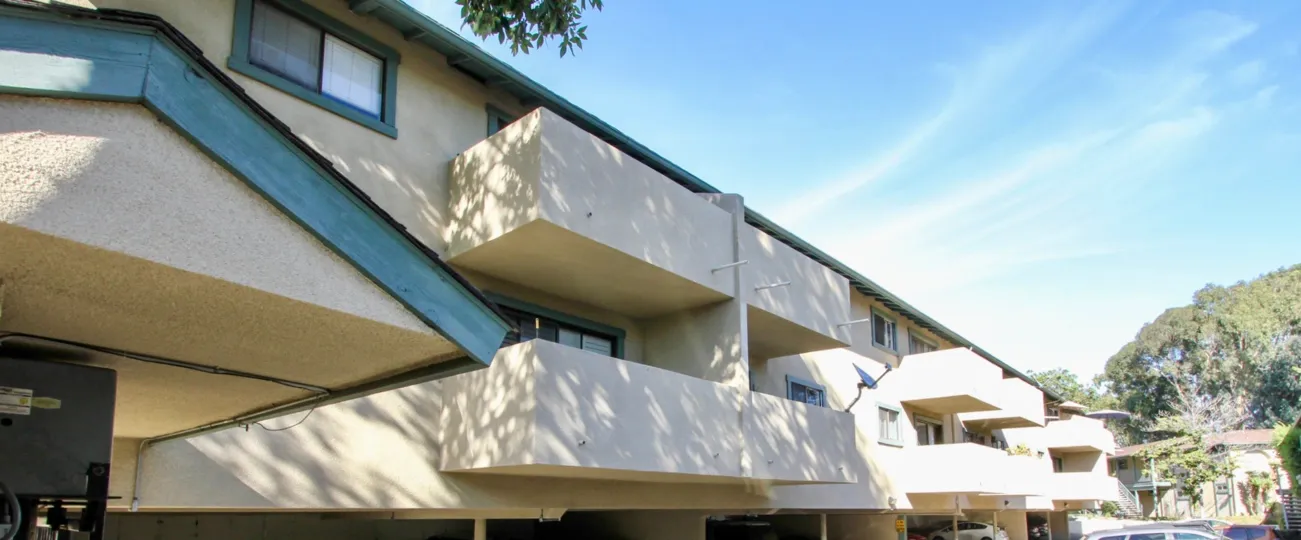A sunny day in the area of Pacific Woodlands, outside, balconies, condos, tree, car